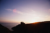 Silhouette einer Burg aus Stein an der Küste, Schottland