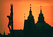 Silhouette der Statue von Jesus Christus und der Kathedrale bei Sonnenuntergang, Karlsbrücke, Prag, Tschechische Republik