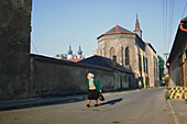 Old woman walking on a down street, Prague, Czech Republic