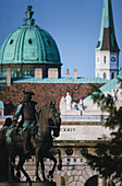 Reiterstatue mit einer Kuppel eines Palastes im Hintergrund, der Hofburg-Komplex, Wien, Österreich