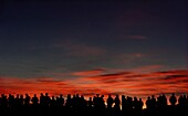 Silhouette eines Volkes, das bei Sonnenuntergang eine Aussicht betrachtet