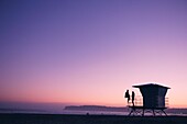 Paar am Rettungsschwimmerturm am Coronado Beach, San Diego, San Diego County, Kalifornien, USA