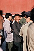 Mann, der sich von einer Masse abhebt und lächelt, Peking, China