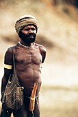 Indigener Mann, der einen Turban trägt und eine Stricktasche über der Schulter trägt und mit einem an der Taille gebundenen Kürbis, Irian Jaya, Neuguinea, Indonesien