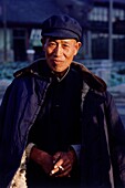 Portrait of an elderly Chinese man holding a cigarette, Datong, China