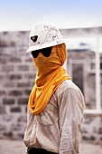Mann mit Schutzhelm, verziert mit Zeichnung einer Frau mit Sonnenbrille und gelbem Tuch über seinem Gesicht zum Schutz während des Bergbaus, Irian Jaya, Neuguinea, Indonesien