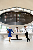 People dressed up as flight attendants and Captains in the lobby of the TWA hotel.