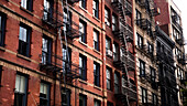 A patch of sunshine hitting an old red brick apartment building in SoHo, New York City.