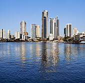 Blick über ruhiges Wasser auf Wohnhäuser und Wohnhochhäuser von Surfers Paradise, aufgenommen von Bundle an der Gold Coast