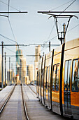 Tram travelling on lines and Surfers Paradise city in the background