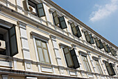 Niedriger Winkel eines langen, mehrstöckigen Gebäudes mit Fensterläden