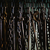 Close up of rusty chains hanging against side of ship