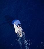 Luftaufnahme einer Yacht (Lion NZ) und ihrer Besatzung, die sich unter vollen Segeln durch das Wasser bewegt
