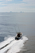 Aerial of speed boat on calm water - rear view
