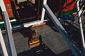 Looking from top of crane down at secured shipping container ready for loading