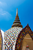 Verziertes Dach des buddhistischen Tempels in Bangkok gegen blauen Himmel