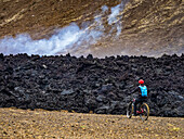 Mountainbiker, einheimische Isländer besuchen Lavaströme vom Vulkan Fagradalsfjall, Island