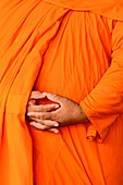 Ein buddhistischer Mönch in Kambodscha mit gefalteten Händen und Safrangewand