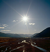 Shingle river bed low in water surrounded by Southern Alps in Arthurs Pass