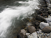 Schnell fließender Fluss über felsigem Flussbett