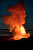 Halbinsel Reykjanes, Island - 9. Mai 2021: Ausbruch des Geldingadalir in der Abenddämmerung mit einer Rauchwolke, die von heißer Lava beleuchtet wird
