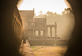 Ein ungewöhnlicher Blick durch ein Fenster entlang einer Galerie von Angkor Wat bei Sonnenaufgang