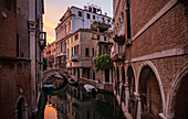 Kleiner Kanal mit Brücke in Venedig im Abendlicht, Italien