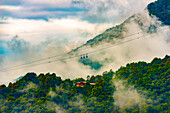 Bergbahn mit Wolken und Sonnenlicht in Miglieglia, Tessin, Schweiz