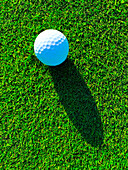 Golfball mit Schatten auf dem Gras auf dem Golfplatz in der Schweiz