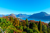 Blick auf die Berge über den Luganersee mit Sonnenlicht und klarem Himmel in Lugano, Tessin in der Schweiz