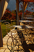 Leeres Restaurant mit Stühlen und Tisch im Freien mit Sonnenlicht im Herbst in Lugano, Tessin in der Schweiz