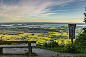 Chiemsee view in the early morning from the Schnappenkirche in the foreground park bench and wooden panel. Chiemsee, Chiemgau, Upper Bavaria, Bavaria, Germany