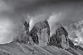 Drei Zinnen in Wolken gehüllt, Toblach, Südtirol, Dolomiten, Italien. Schwarz, weiß.