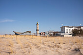 Blick über die Düne zum Leuchtturm in Warnemünde mit der historischen Muschel am Morgen, Rostock, Mecklenburg-Vorpommern, Deutschland
