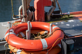 Nahaufnahme eines orangen Rettungringes auf einem Fischerboot am alten Strom in Warnemünde, Rostock, Mecklenburg-Vorpommern, Deutschland