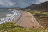 View of Rhossili Beach with lonely house. Coastguard Cottages, Wales.