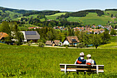 älteres Wandererpaar auf einer Bank, St Peter, Schwarzwald, Baden-Württemberg, Deutschland