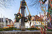 mit bunten Ostereiern und farbigen Bändern geschmückter Osterbrunnen in Muggendorf in der Fränkischen Schweiz, Bayern, Deutschland