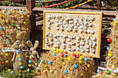 Frohe Ostern Tafel mit Eierschalen am der mit bunten Ostereiern geschmückte Osterquelle an der Trubachquelle in Obertrubach in der Fränkischen Schweiz, Bayern, Deutschland