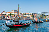 Barcos Rabelos, port wine boats on the Duero River in front of the Dom Luís I Bridge and the historic old town of Porto, Portugal