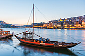 Barcos Rabelos, Portweinboote auf dem Fluss Duero vor der historischen Altstadt von Porto bei Nacht, Portugal