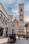 Carriage in front of the Baptistery and facade of the Duomo, Cathedral of Santa Maria del Fiore, Florence, Tuscany, Italy