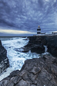 Loop Head lighthouse on cliffs in stormy seas. After sunset. Churchtown, County Wexford, Ireland.tif