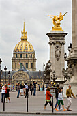 People on Pont Alexandre III, Paris , France with Les Invalides in the backgroun