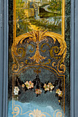 Goldgerahmtes Wandbild in der Rue des Francs Bourgeois mit einer Mühle und Blumen, Marais, Paris, Frankreich