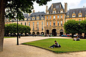 Young woman reading, Place des Vosges, The Marais, Paris, France