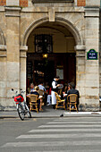Leute sitzen in einem Café mit einem Kellner, Place des Vosges, Marais, Paris, Frankreich