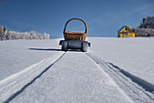 Schlittentransportkorb über hügelige, verschneite Winterlandschaft, Estland