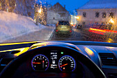 Car interior and illuminated street view. Dashboard, speedometer