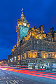Uhrturm des Balmoral Hotels nachts beleuchtet mit Ampelunschärfe unten, Edinburgh, UK